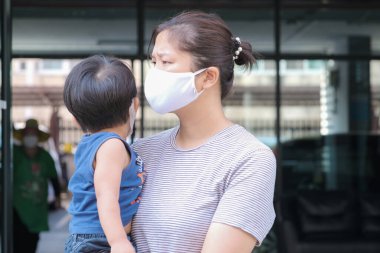 Yüzünde maske olan çocuk olan bekar bir anne. Anne ve çocuk koronavirüs ve grip salgını sırasında yüz maskesi takıyor. Virüs ve hastalık koruması