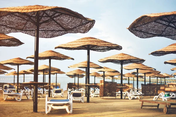 Getinte afbeelding hotel strand met parasols en ligstoelen, h — Stockfoto