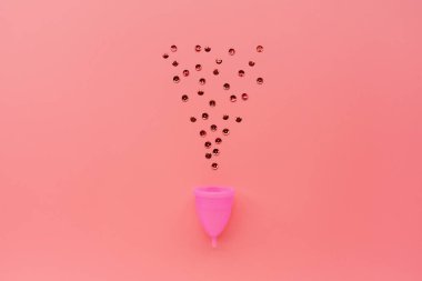 Pembe arka planda regl fincanı. O dönemde alternatif kadın hijyen ürünü. Kadın sağlığı konsepti. Uzayı kopyala Çevre dostu kavram, sıfır atık ürün. Düz yatış, model, şablon