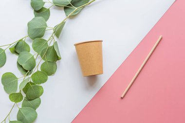 Çevresel kağıt kahve fincanı ve saman düz beyaz ve pembe arka planda yatıyordu. Sürdürülebilir yaşam tarzı kavramı. sıfır atık, plastiksiz eşyalar. Plastik kirliliğini durdurun. Üst görünüm, genel görünüm, model şablonu