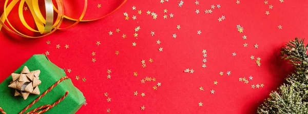 크리스마스 선물, 황금 색종이와 빨간색 배경에 나무 가지. 웹 디자인을 위한 수평 배너. 새해 개념. 인사말 카드, 2020 년 축하. 플랫 레이, 상단 보기, 복사 공간, 모형 — 스톡 사진