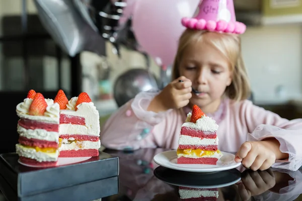 Beltéri felvétel elég vidám kislány szőke haj elfújja a gyertyát, ünnepli 6 éves születésnapját, viselni divatos ruhát, van izgatott kifejezések. Boldog gyermekkori koncepció — Stock Fotó