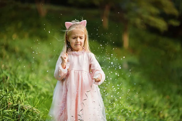 Niña con estilo con el pelo rubio lanzando confeti en el parque. Cumpleaños celebración al aire libre, diversión niño ocio —  Fotos de Stock