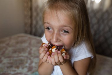 Çocuk elleri turuncu kalp şeklinde şeker tutuyor.