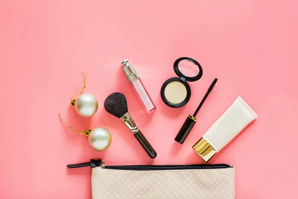Flat lay composition with makeup products and Christmas decor on pink background. Top view, template, mockup. Xmas, happy new year 2020 concept, female wishes concept