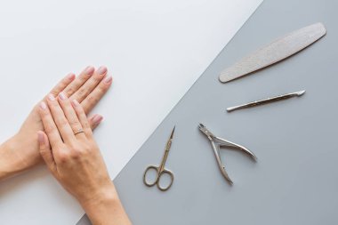 Modaya uygun pembe kadın manikürü. Gri arka planda güzel genç bir kadın elleri var. Asgari yaratıcı konsept. Düz konum, üst görünüm, maket, boşluk kopyala, şablon
