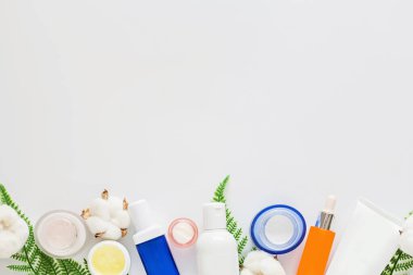 Doğal organik kozmetiklerle yatıyordu: serum, beyaz arka planda yeşil yapraklı krem. Cilt bakımı, kozmetoloji, cilt bakımı. Güzellik sertifikası, blog tarzı. Üst görünüm, üst görünüm, genel görünüm