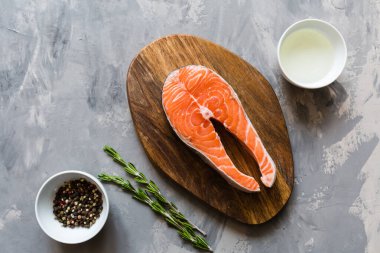 Koyu taş arka plan üzerinde baharat ile taze çiğ somon balık biftek. Balık, üst görünüm, düz yatıyordu, mockup, havai yapılmış Yaratıcı düzeni. Sağlıklı gıda kavramı