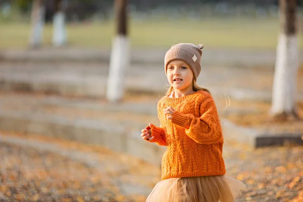 Jolie petite fille élégante marchant dans le parc d'automne avec des arbres ginkgo. Mode d'automne pour enfants. Bonne enfance. Portrait de style de vie — Photo