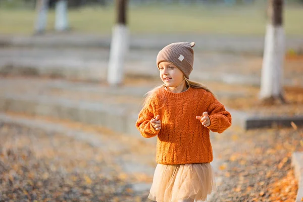 Jolie petite fille élégante marchant dans le parc d'automne avec des arbres ginkgo. Mode d'automne pour enfants. Bonne enfance. Portrait de style de vie — Photo