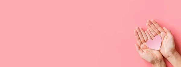Fondo del día de San Valentín. Manos femeninas sosteniendo el hogar rosa. Colocación plana, vista superior, maqueta, plantilla, espacio para copiar. Composición abstracta mínima para la celebración del 14 de febrero — Foto de Stock