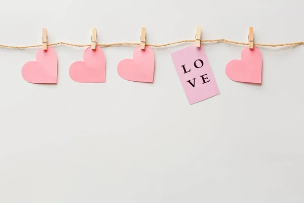 Fondo del día de San Valentín con corazones rosados y el amor de la tarjeta en blanco. Colocación plana, vista superior, maqueta, plantilla, espacio para copiar. Composición abstracta mínima para la celebración del 14 de febrero — Foto de Stock