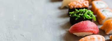 Geleneksel Japon restoranının suşi, zencefil, soya sosu, çimento grisi arka planda wasabi ile en üst görüntüsü. Çevrimiçi gıda teslimatı kavramı