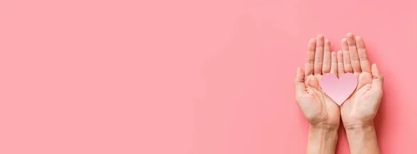 Fondo del día de San Valentín. Manos femeninas sosteniendo el hogar rosa. Colocación plana, vista superior, maqueta, plantilla, espacio para copiar. Composición abstracta mínima para la celebración del 14 de febrero — Foto de Stock