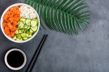 Hawaii somon kasesi, salatalık, avokado, susam tohumu ve pilav. Üst görünüm, genel görünüm, düz görünüm, model, şablon. Sağlıklı gıda konsepti