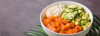 Hawaii somon kasesi, salatalık, avokado, susam tohumu ve pilav. Üst görünüm, genel görünüm, düz görünüm, model, şablon. Sağlıklı gıda konsepti