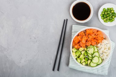 Hawaii somon kasesi, salatalık, avokado, susam tohumu ve pilav. Üst görünüm, genel görünüm, düz görünüm, model, şablon. Sağlıklı gıda konsepti