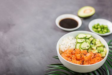 Hawaii somon kasesi, salatalık, avokado, susam tohumu ve pilav. Üst görünüm, genel görünüm, düz görünüm, model, şablon. Sağlıklı gıda konsepti