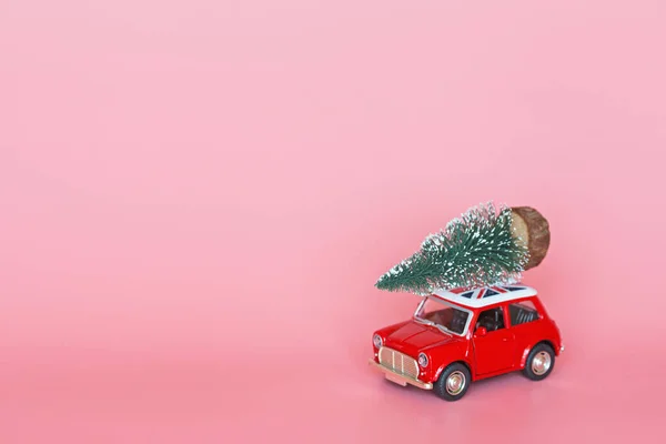 중국 - 2019 년 10 월 15 일: 분홍색 종이 배경에 크리스마스 트리가 있는 빨간 장난감 자동차. 겨울 배달 , Xmas, Happy New Year 2020 celebration 컨셉트. 인사 카드, 흉내 — 스톡 사진