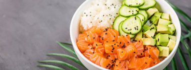 Hawaii somon kasesi, salatalık, avokado, susam tohumu ve pilav. Üst görünüm, genel görünüm, düz görünüm, model, şablon. Sağlıklı gıda konsepti