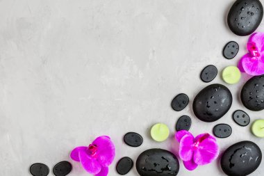 Sıcak spa taşlarının üst görüntüsü masaj için ayarlanmış gri beton arka planda fotokopi alanı ile. Zarif ve lüks bir spa. Düz yatış, genel giderler, modelleme, şablon. Sağlık ve güzellik hizmetleri kavramı