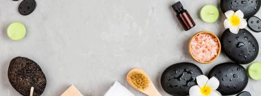 Sıcak spa taşlarının üst görüntüsü masaj için ayarlanmış gri beton arka planda fotokopi alanı ile. Zarif ve lüks bir spa. Düz yatış, genel giderler, modelleme, şablon. Sağlık ve güzellik hizmetleri kavramı