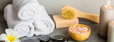 Gri beton arka planda masaj için sıcak spa taşları ayarlandı. Zarif ve lüks bir spa. Model, şablon. Sağlık ve güzellik hizmetleri kavramı