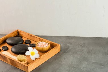 Sıcak spa taşlarının üst görüntüsü masaj için ayarlanmış gri beton arka planda fotokopi alanı ile. Zarif ve lüks bir spa. Düz yatış, genel giderler, modelleme, şablon. Sağlık ve güzellik hizmetleri kavramı