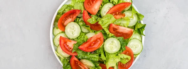 Gesundes vegetarisches Gericht auf dem Tisch, Gemüsesalat mit frischen Tomaten, Gurken, Salat, roter Zwiebel auf grauem Betongrund. Ernährungsmenü. Ansicht von oben. flache Verlegung, Attrappe, Vorlage mit Kopierraum — Stockfoto