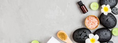 Sıcak spa taşlarının üst görüntüsü masaj için ayarlanmış gri beton arka planda fotokopi alanı ile. Zarif ve lüks bir spa. Düz yatış, genel giderler, modelleme, şablon. Sağlık ve güzellik hizmetleri kavramı