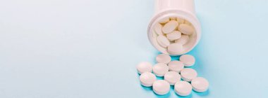 Pastel mavi arka planda beyaz haplar. Düz konum, üst görünüm, genel görünüm, model, şablon, kopyalama alanı. Eczane ve tıbbi konsept