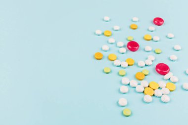 Pastel mavi arka planda renkli haplar. Düz yatış, üst görünüm, genel görünüş, model, şablon. Eczane ve tıbbi konsept