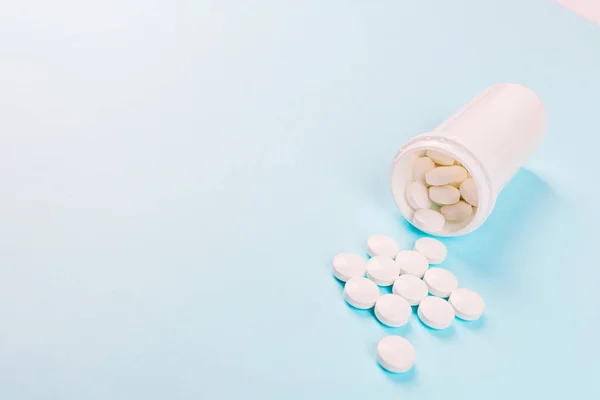 Pastillas blancas sobre fondo azul pastel. Colocación plana, vista superior, sobrecarga, maqueta, plantilla, espacio para copiar. Farmacia y concepto médico — Foto de Stock