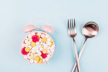 Pastel mavi arka planda renkli haplar. Düz yatış, üst görünüm, genel görünüş, model, şablon. Eczane ve tıbbi konsept