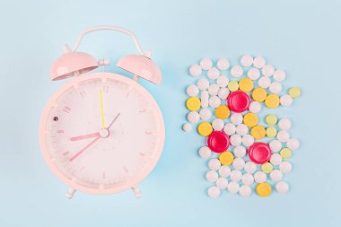 Beyaz haplar ve mavi arka planda şırınga. Düz konum, üst görünüm, genel görünüm, model, şablon, kopyalama alanı. Eczane ve tıbbi konsept