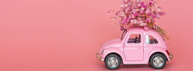 Changxing, Çin - 15 Ekim 2019: pembe arka planda çiçek buketi teslim eden pembe retro oyuncak araba. Sevgililer Günü, 14 Şubat kartı. Uluslararası Kadınlar Günü 8 Mart, Anneler Günü, Doğum günü hediyesi. C