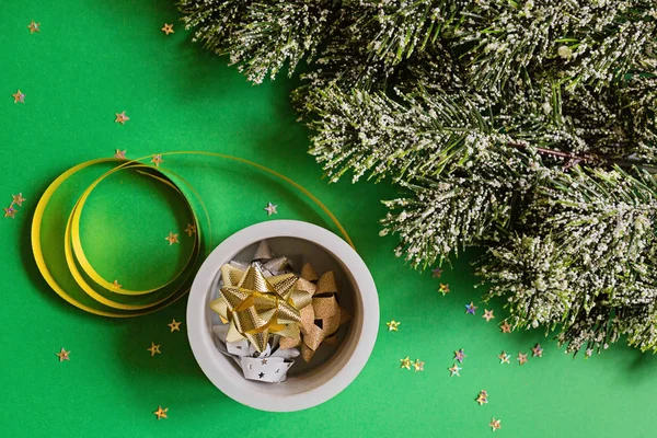 Різдвяні обгорткові стрічки та ялинкові гілки на зеленому фоні з конфетті. концепція нового року. Вітальна листівка, святкування Різдва 2020 року. Плоский шар, шаблон, вид зверху — стокове фото