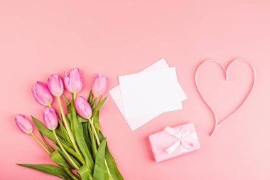 Yukarıdan laleleri ve fotokopi alanı olan hediye kutusunu izle. Kadınlar Günü için arka plan, 8 Mart Sevgililer Günü, 14 Şubat. Düz yatış stili, üst görünüm, model, şablon, genel giderler. Tebrik kartı