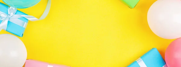 Verjaardagsballonnen en geschenken op gele achtergrond, bovenaanzicht. Vlakke lay stijl. Mockup, sjabloon. Horizontale lange banner voor webdesign — Stockfoto