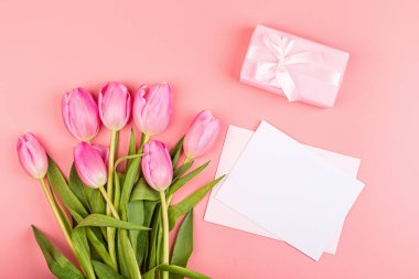 Yukarıdan laleleri ve fotokopi alanı olan hediye kutusunu izle. Kadınlar Günü için arka plan, 8 Mart Sevgililer Günü, 14 Şubat. Düz yatış stili, üst görünüm, model, şablon, genel giderler. Tebrik kartı