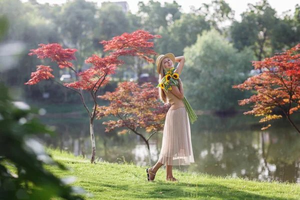Porträt einer schönen Frau mit Sonnenblumen — Stockfoto
