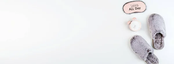 Asiento plano con suaves zapatillas esponjosas de color gris y reloj despertador rosa aislado sobre fondo blanco. vista superior, gastos generales, maqueta, plantilla, espacio para copiar. Tiempo de descanso — Foto de Stock