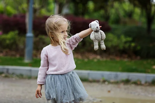 Дитина тримає брудний фарширований плюшевий ведмідь на відкритому повітрі — стокове фото