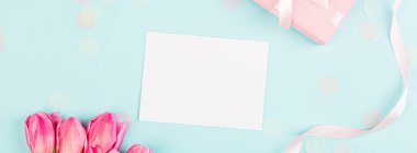 Yukarıdan laleleri ve mavi üzerinde fotokopi alanı olan hediye kutusunu izle. Kadınlar Günü için arka plan, 8 Mart Sevgililer Günü, 14 Şubat. Düz yatış stili, üst görünüm, model, şablon, genel giderler. Tebrik kartı
