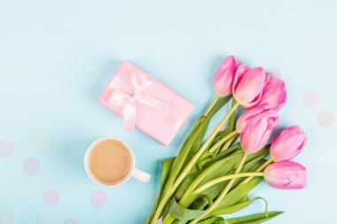 Yukarıdan laleleri ve mavi hediye kutusunu seyret. Kadınlar Günü için arka plan, 8 Mart Sevgililer Günü, 14 Şubat. Düz yatış stili, üst görünüm, model, şablon, genel giderler. Tebrik kartı