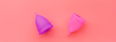 Pembe arka planda regl bardakları. O dönemde alternatif kadın hijyen ürünü. Kadın sağlığı konsepti. Uzayı kopyala Çevre dostu kavram, sıfır atık ürün. Düz yatış, model, şablon