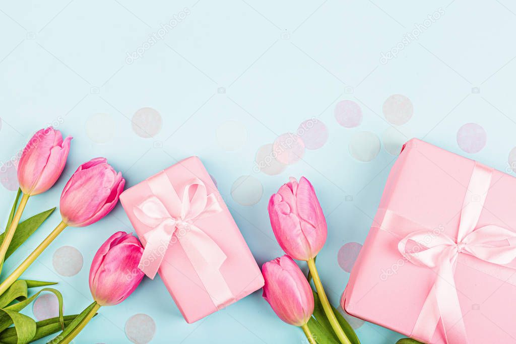 View from above tulips and gift box with copy space on blue. Background for womens day, 8 March Valentines day, 14 february. Flat lay style, top view, mock up, template, overhead. Greeting card