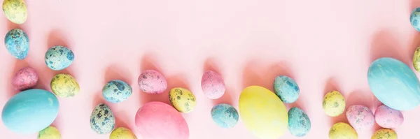 Stílusos háttér színes húsvéti tojás elszigetelt rózsaszín pasztell háttér virágzó cseresznyefa ágak. Vízszintes hosszú banner web design. Lapos fektetés, felülnézet, mockup, rezsi, sablon — Stock Fotó