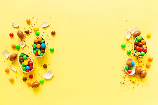 Шоколадные Пасхальные Яйца Красочные Конфеты Фоне Желтой Бумаги Плоская Кладка — стоковое фото