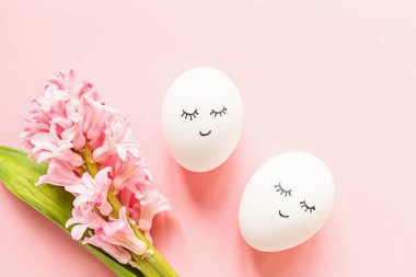 Tatlı yüzlü yaratıcı paskalya yumurtaları ve pastel pembe arka planda uykulu gözler. Mutlu Paskalyalar. Düz konum, üst görünüm, model, şablon, genel görünüm, boşluğu kopyala.
